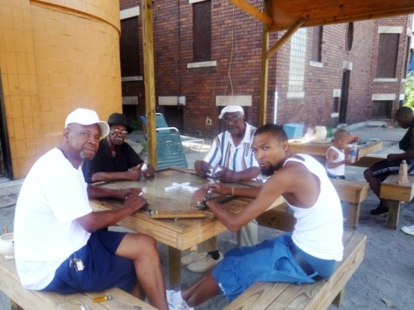 Central Detroit residents have transformed an abandoned gas station into a gathering place at Peaches & Greens, complete with new furniture and a pavilion structure to protect domino players from the elements. / Photo: Steve Davies / Peaches & Greens